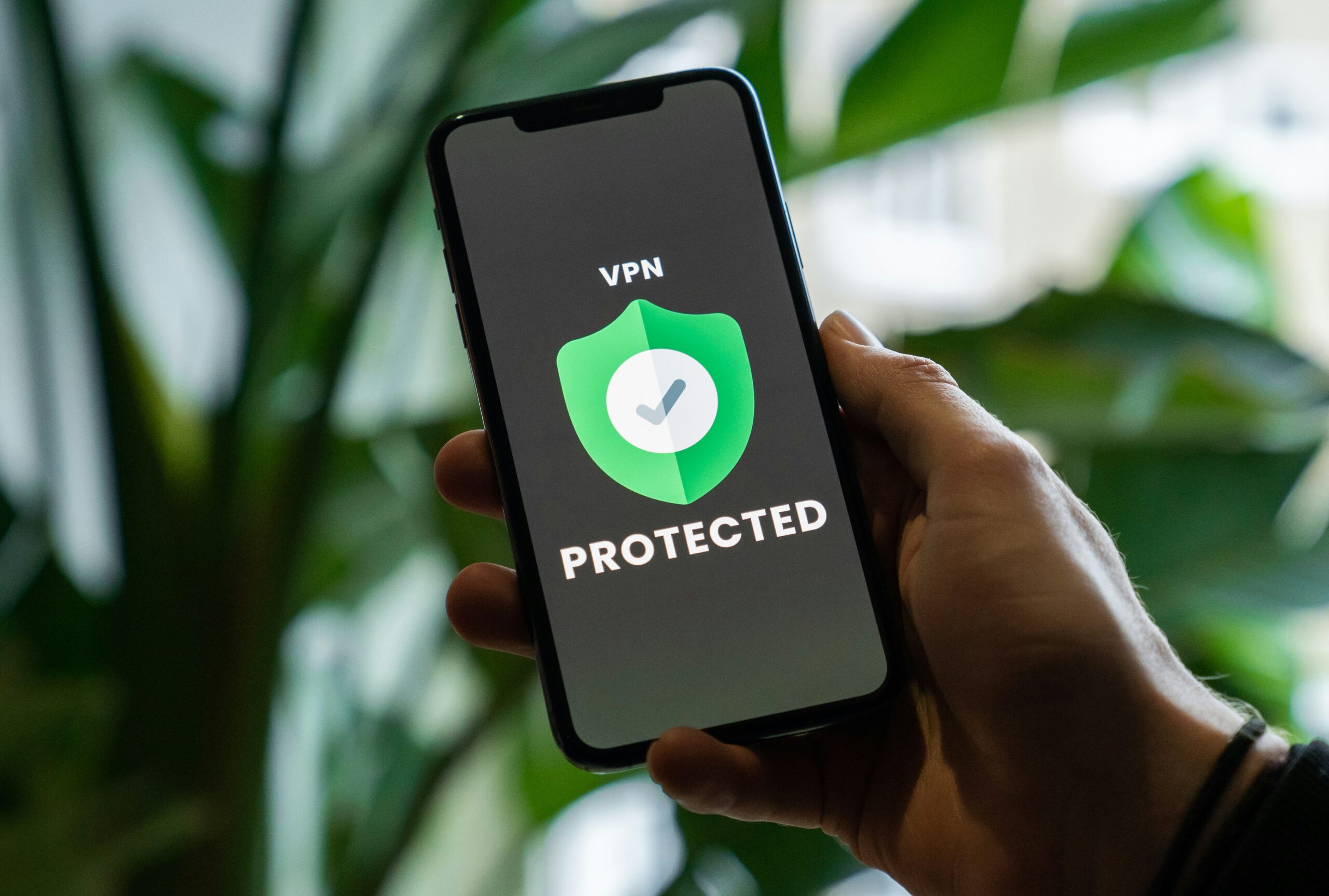 A person holding up a phone with a VPN on it after reading about the essential cyber security tips.